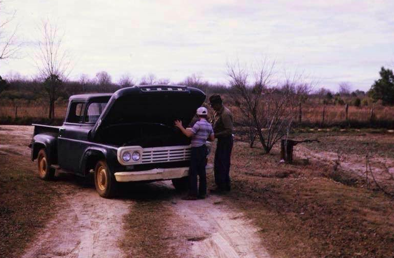 Vintage photo of a man working on a classic pickup truck — a nod to Snider Auto Care's roots